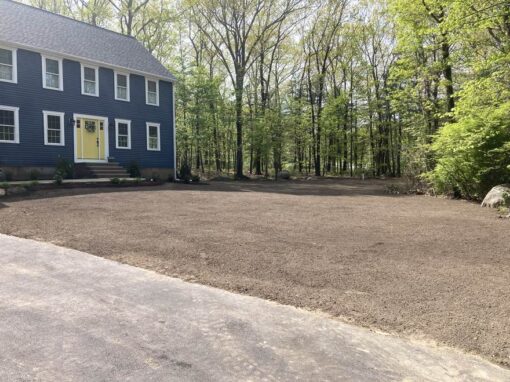 Graded and loamed front yard ready for lawn installation at a blue colonial