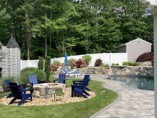 Fire pit with blue Adirondack chairs and a flagstone path, one of our outdoor seating areas