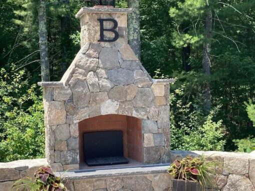 Fieldstone fireplace with seat walls and planters on a paver patio