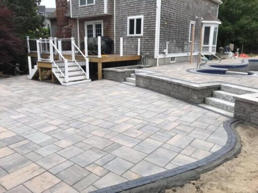 Big paver patio with a raised spa wall, with room for an outdoor kitchen