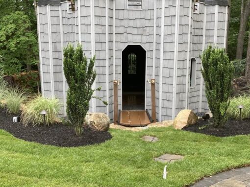 Castle playhouse with plantings where kids play, a priority area for tick spraying