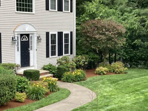 Trimmed shrubs and a crisp lawn along a curved front walk