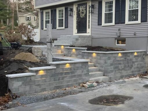 Segmental block wall with step lights at a colonial front entry
