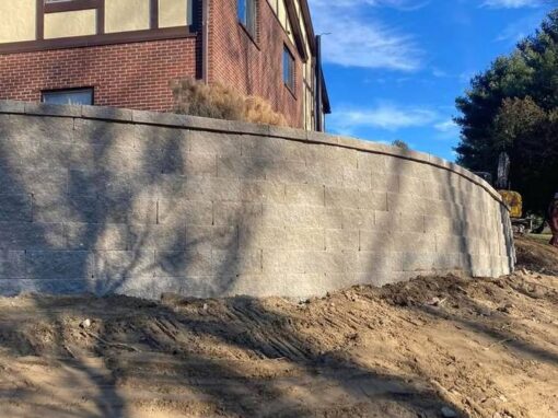 Curved concrete retaining wall and regraded slope at a condominium