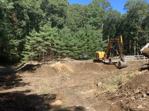 Cleared and rough-graded wooded lot with an excavator