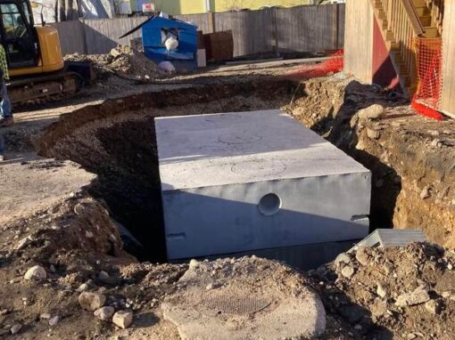 Setting a precast concrete tank in an excavation near a building