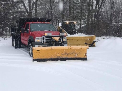 Red plow truck and loader ready at the yard