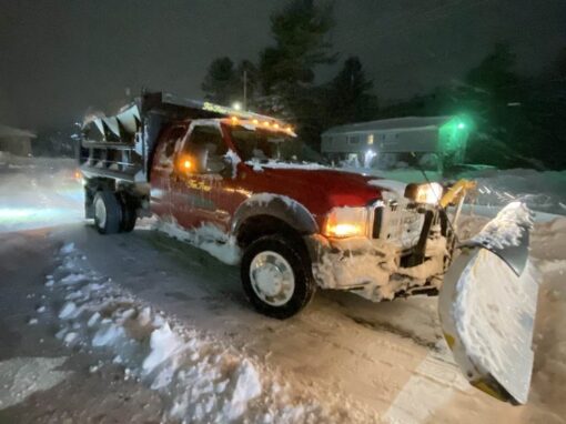 Plow truck clearing snow at night