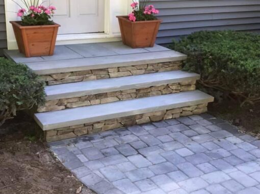 Bluestone treads over stone risers leading to a front door with planters